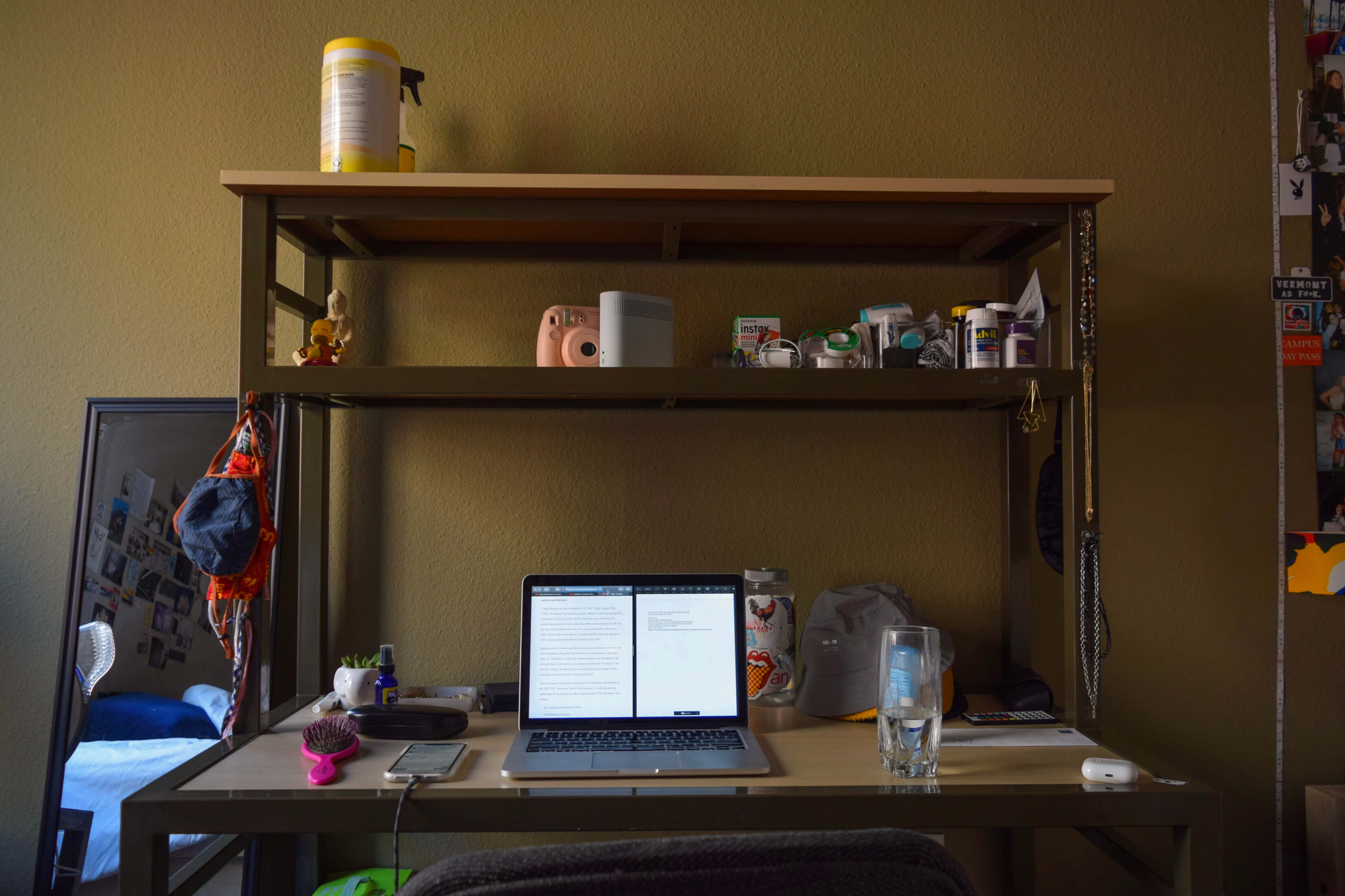 A dorm desk with laptop and other trinkets